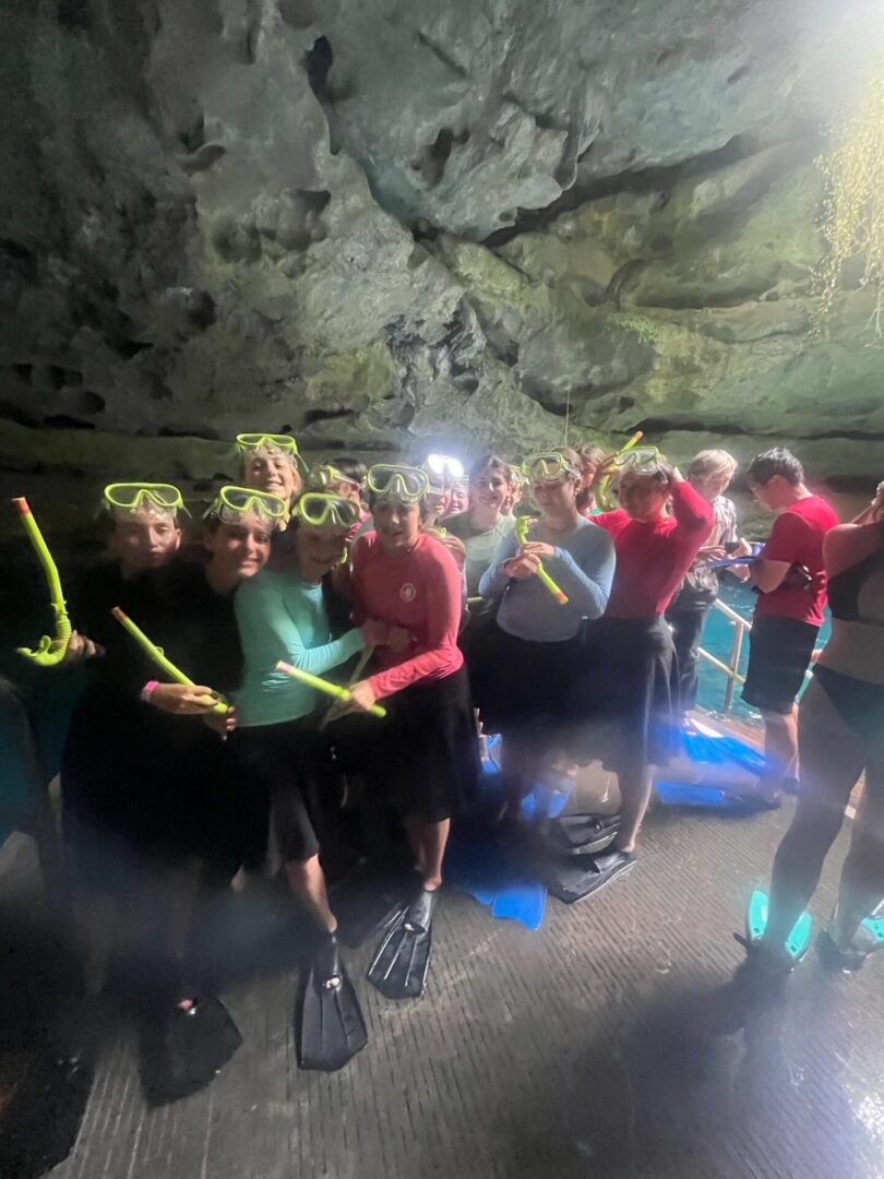 Group of people in wetsuits preparing for a dive inside a cave.