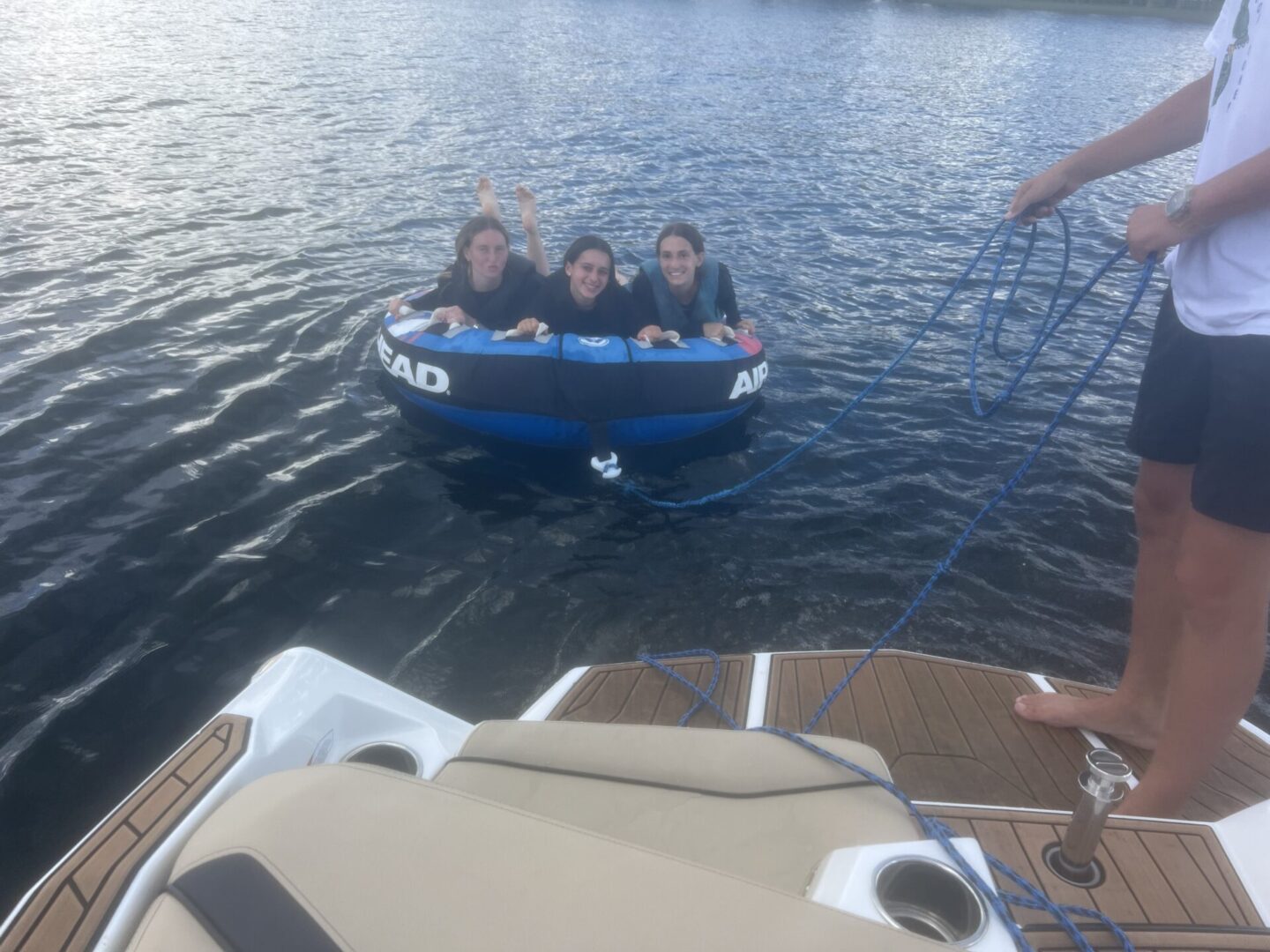 Four people enjoying a small inflatable boat on a lake.