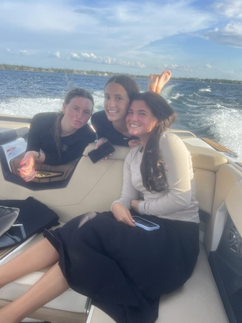 Three friends enjoying a boat ride on a sunny day.