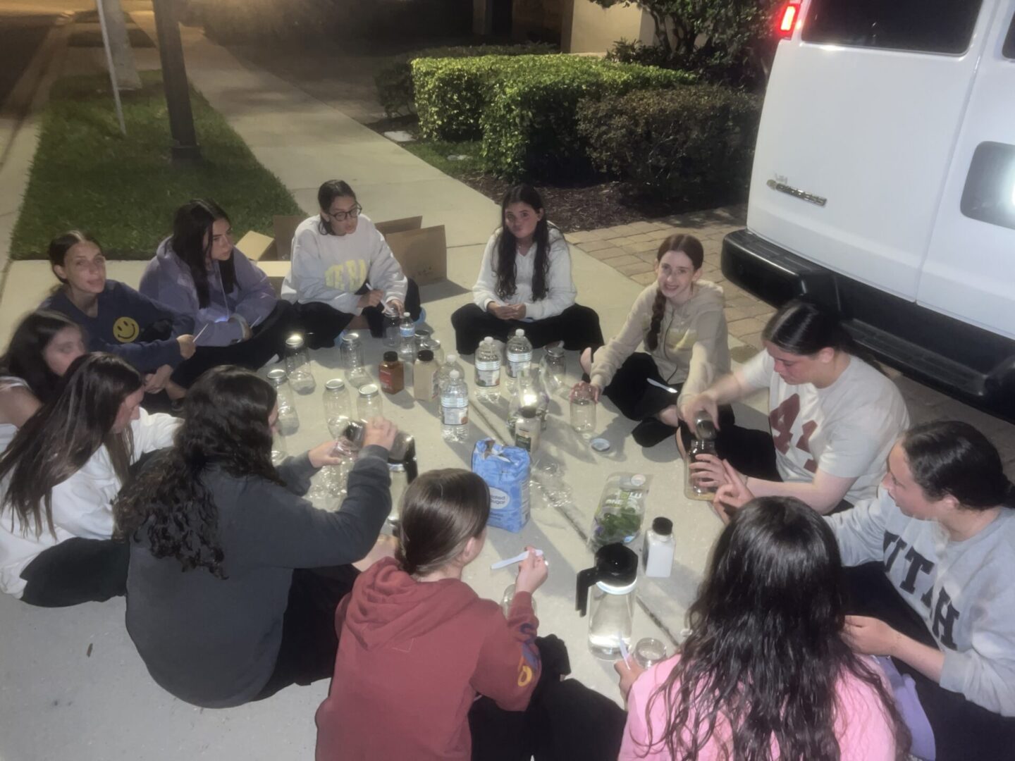 Group of friends enjoying an outdoor dinner around a table at night.