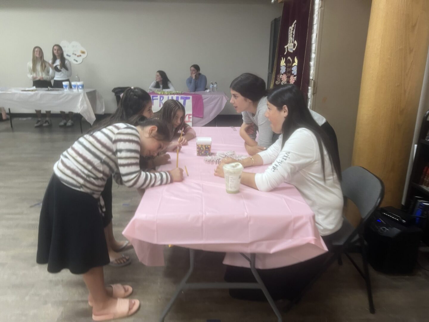 Children and adults engaging in a craft activity at a table.