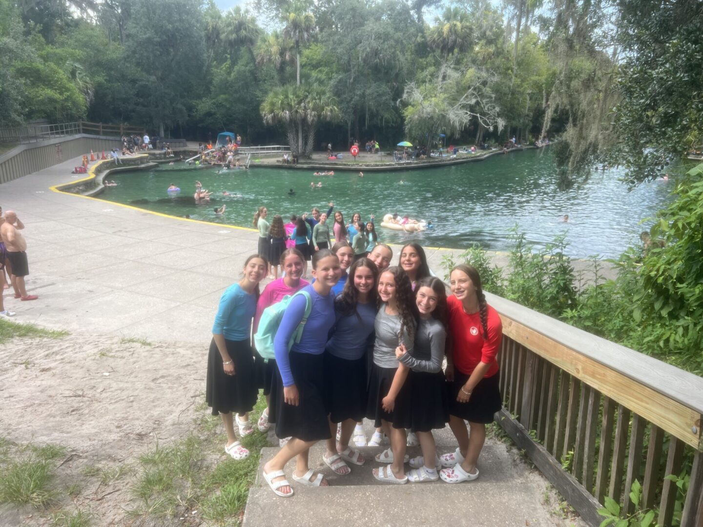 Group of friends posing on a wooden bridge in a park.