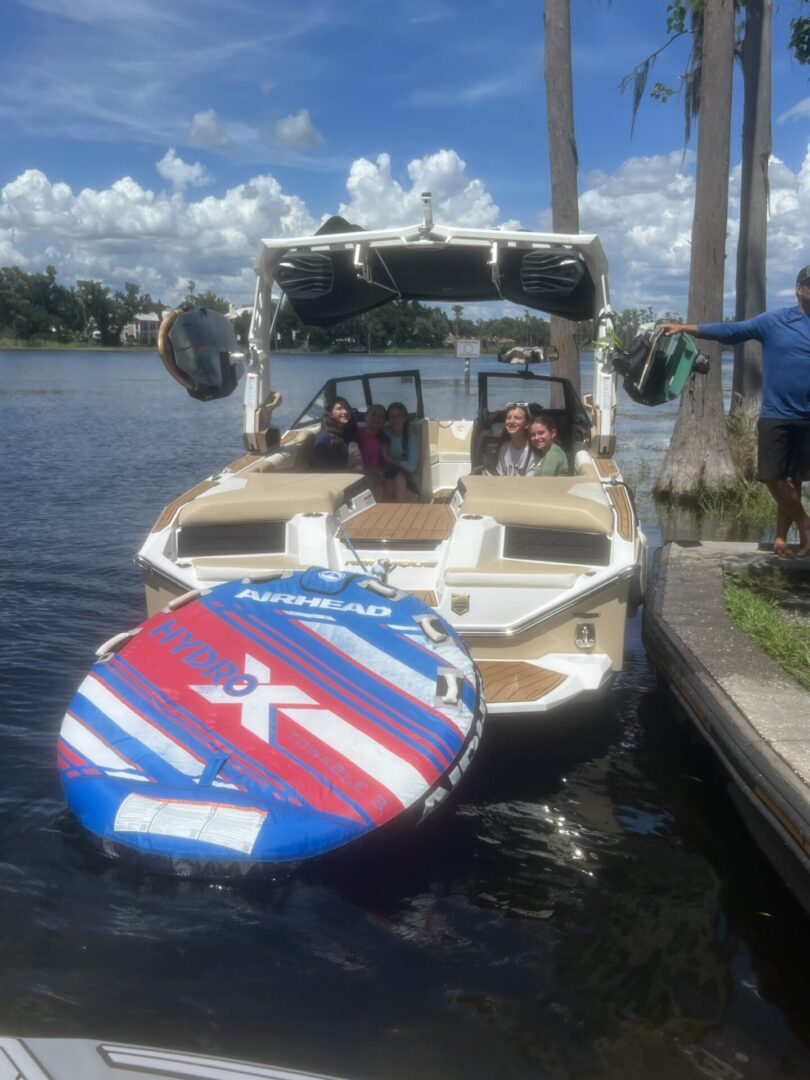 Boat docked with a colorful paddleboard on the back.