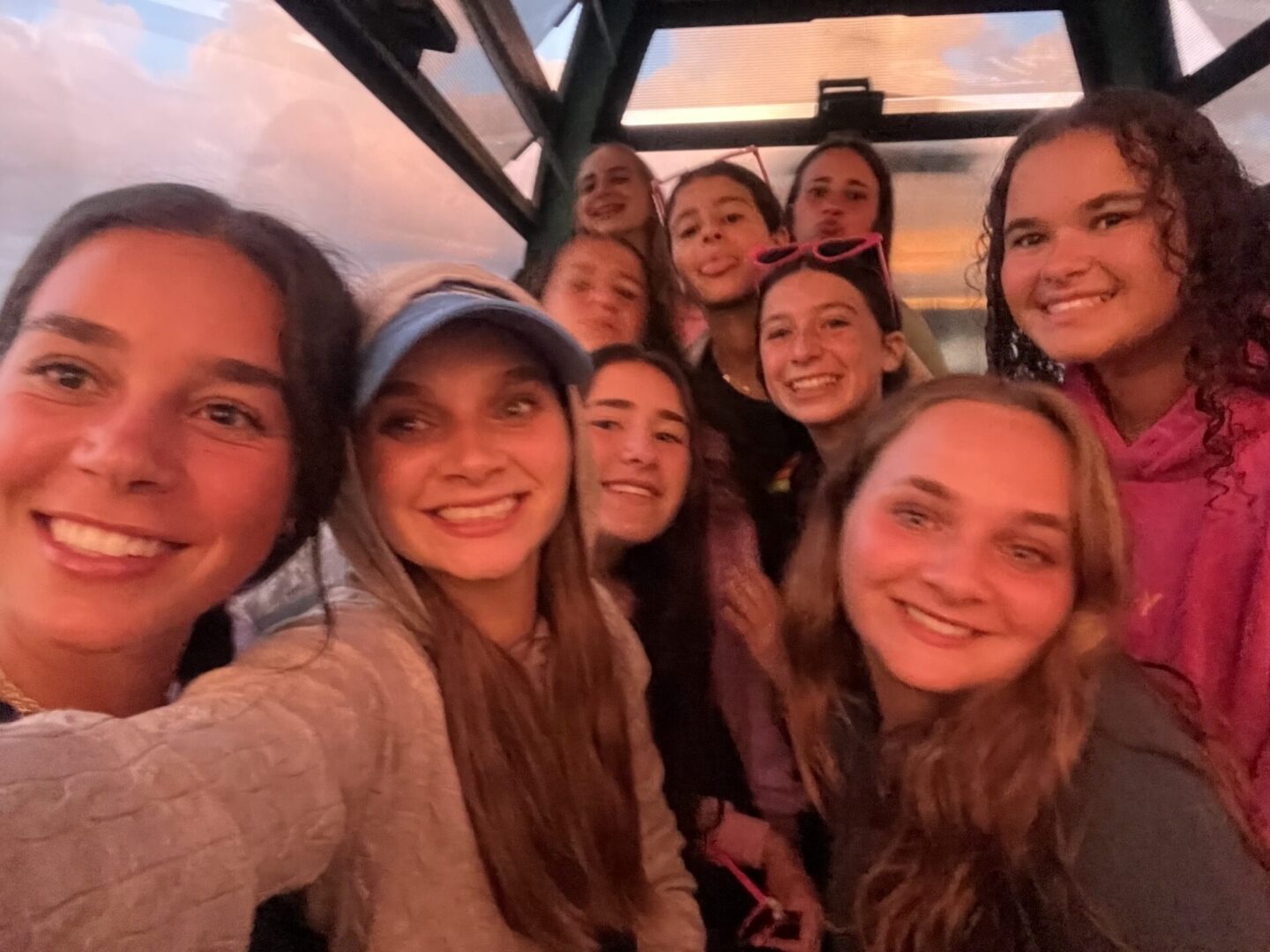 A group of friends smiling together for a selfie indoors.
