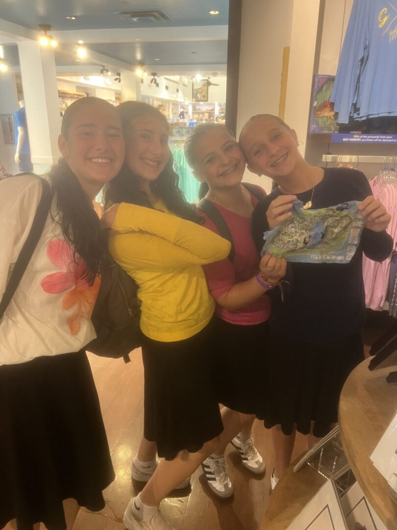 Four people smiling and posing together indoors.