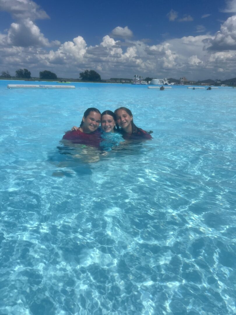 Three friends enjoying clear blue water on a sunny day.