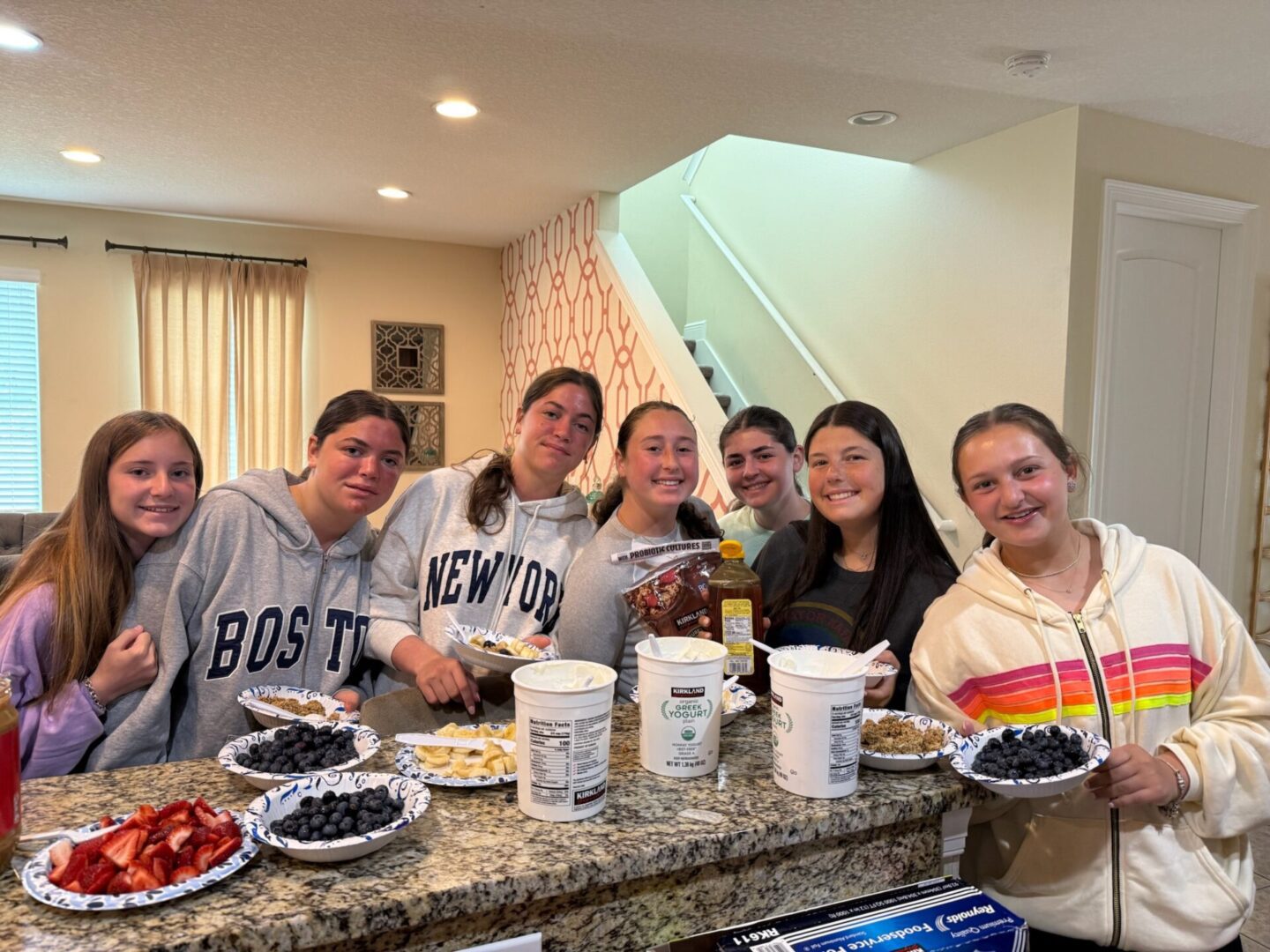 Group of friends enjoying a casual gathering in a kitchen.