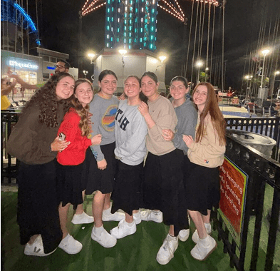 Group of friends posing together outdoors at night.